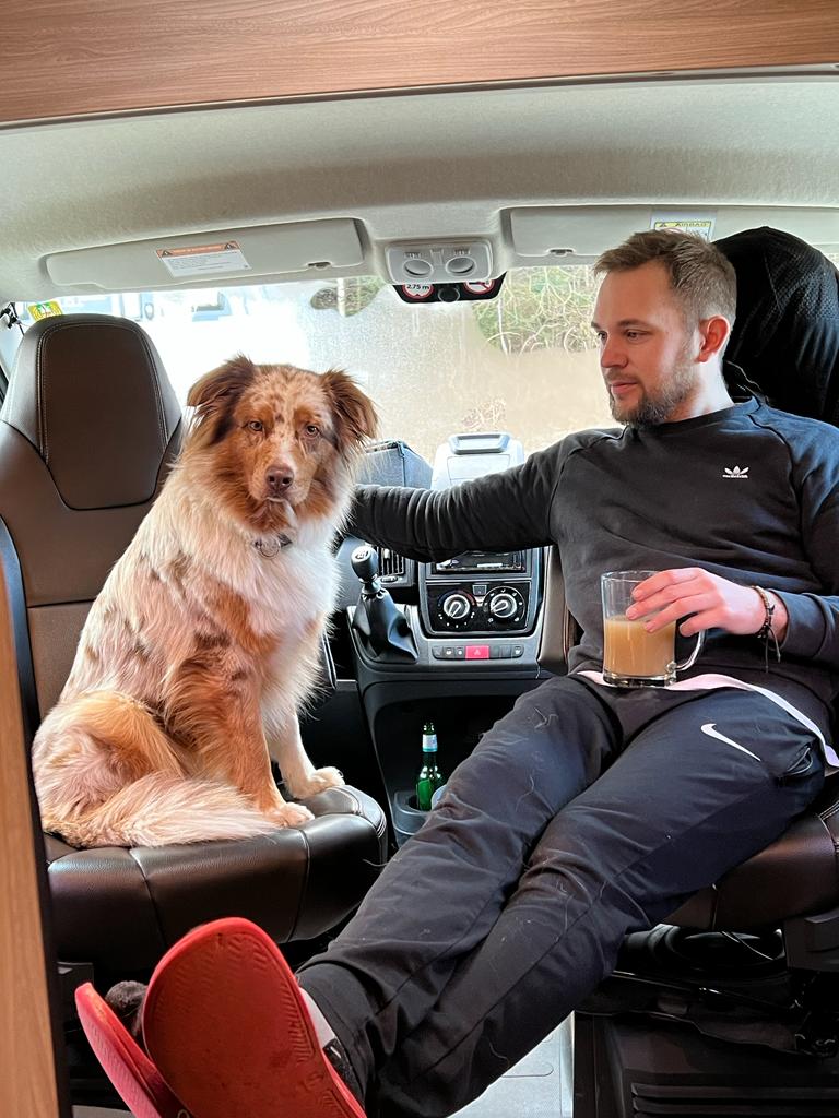 Der Fotograf mit seinem Hund beim Kaffeetrinken im Van