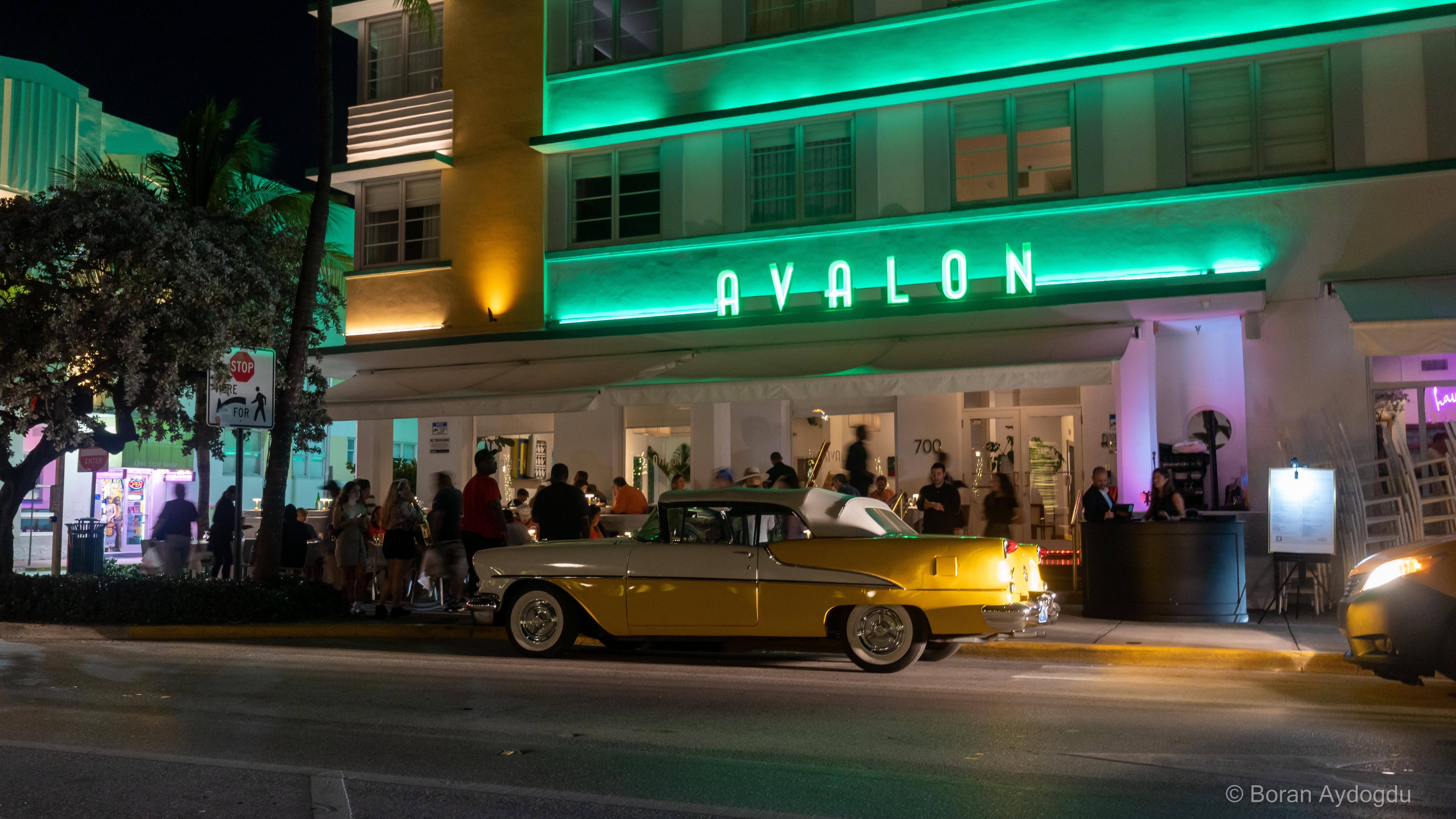 Das Avalon Hotel bei Nacht, gelber Oldtimer vorm Hotel. Frontview