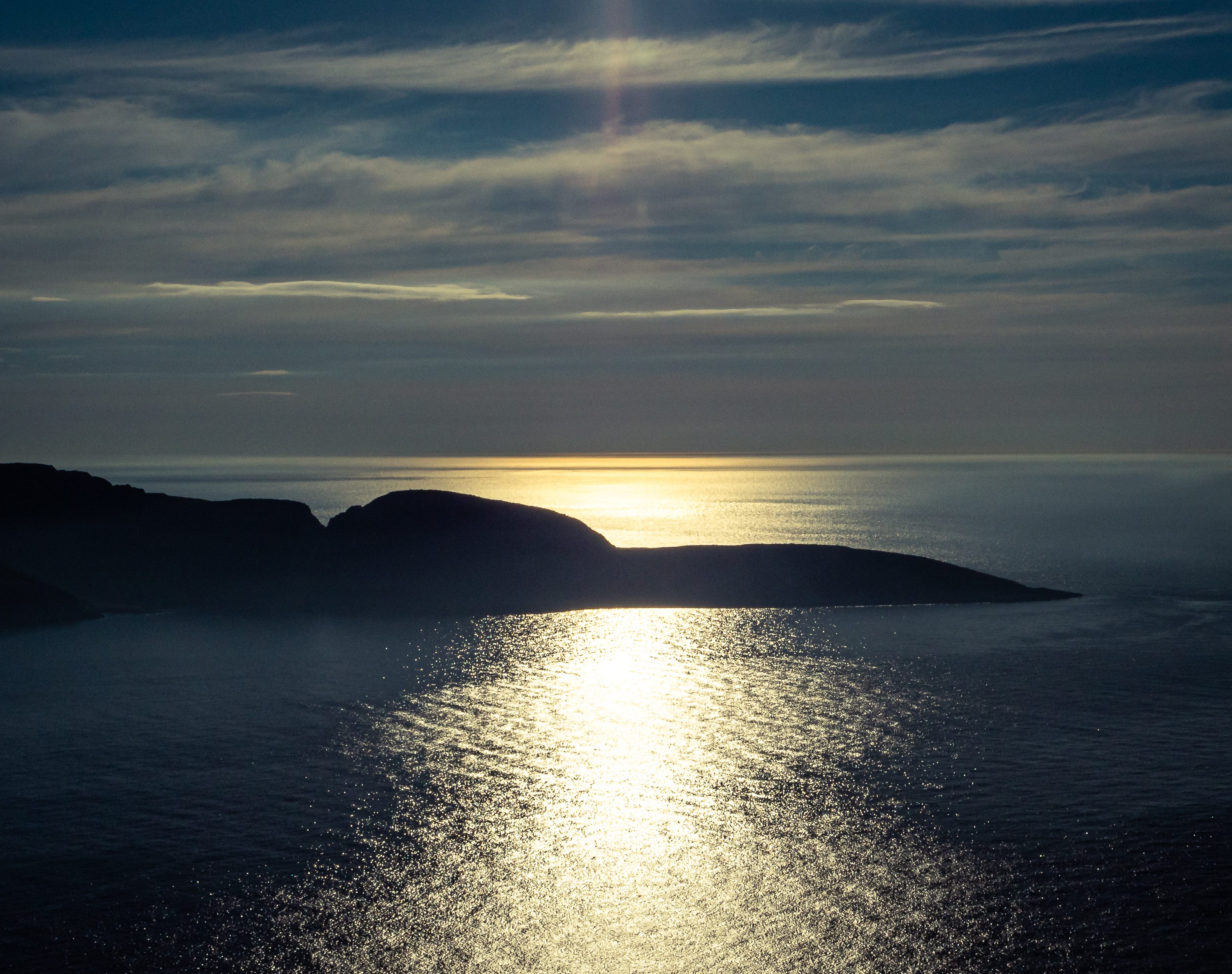 Das norwegische ruhige Meer. Hügel ragen aus dem Wasser und die Sonne strahlt drauf